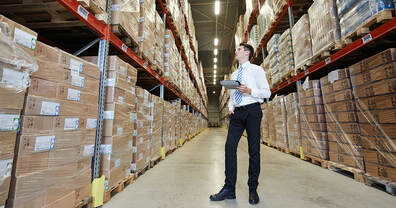 man in warehouse checking stock levels